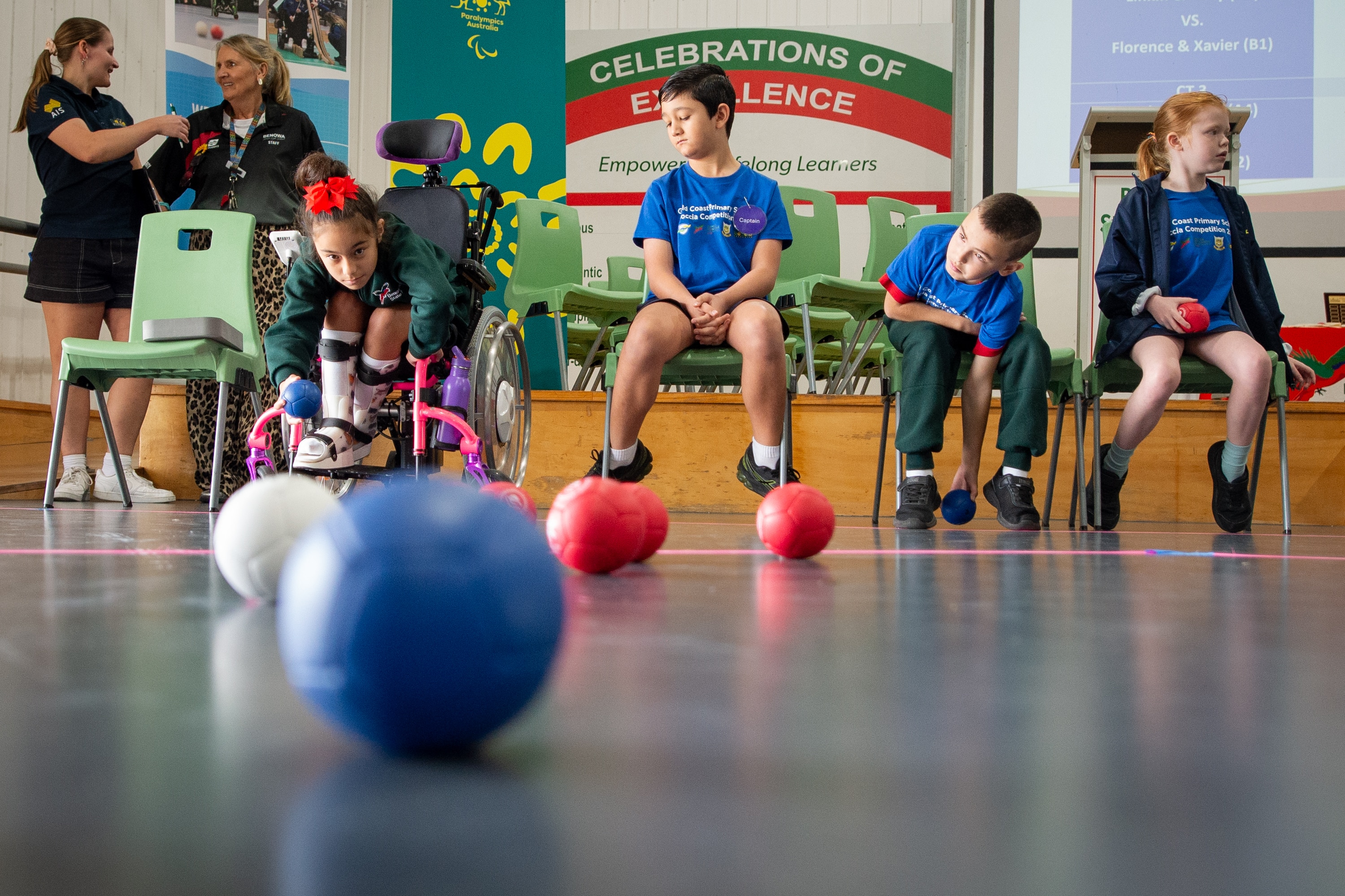 A group of children play a game using coloured balls.