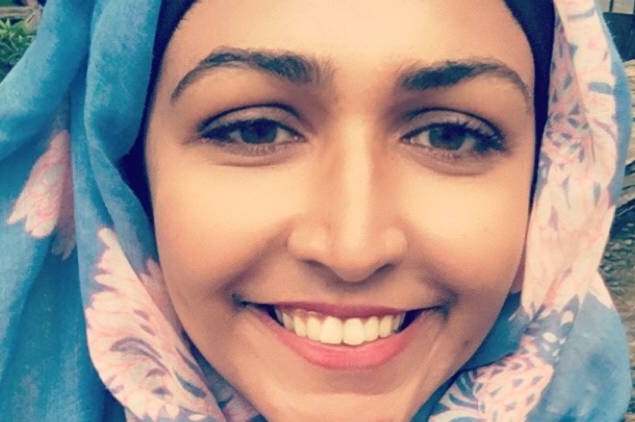 A close-up of a smiling woman wearing a head scarf