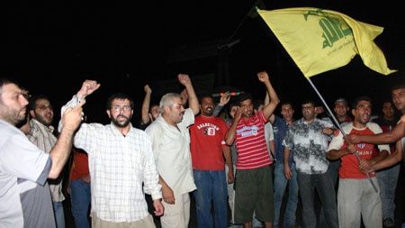 Lebanese people cheer the speech of Hezbollah chief Hassan Nasrallah.