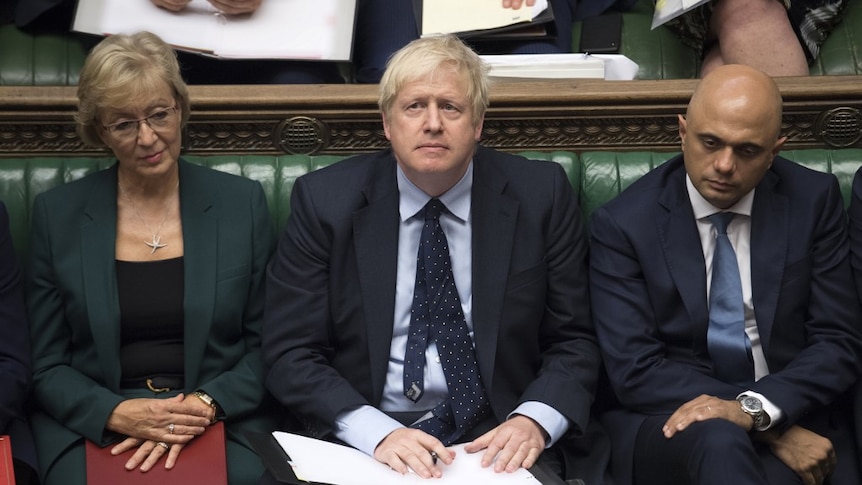 Boris Johnson is looking up as he sits in between Andrea Leadsom and Sajid Javid  in the house of commons