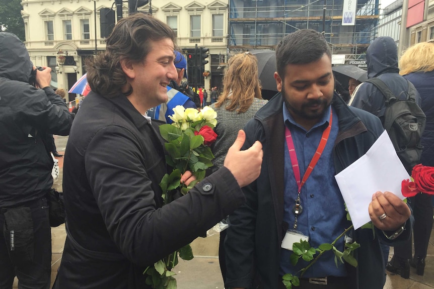 Mutu Sancaktutarsmiles as he hands out a rose and a message.