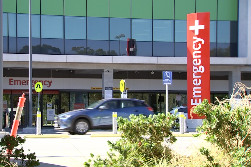 A car drives past an emergency department building