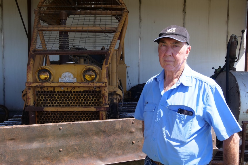 A man standing in front of a bulldozer