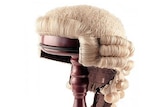 A barrister wig on a wooden stand.