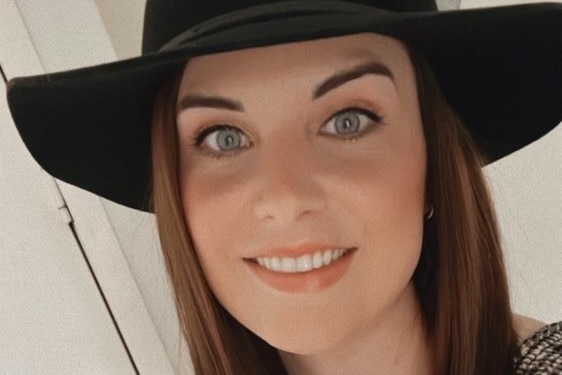 Women with blue eyes and brown hair wearing a black hat