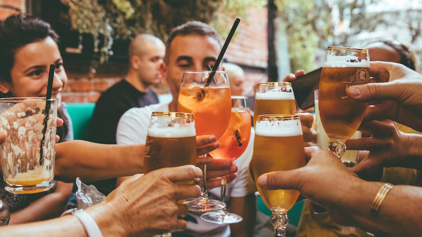 A group of people celebrate with drinks at a bar 