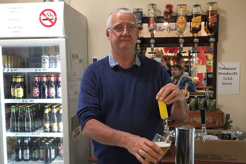 Peter Grayson pulls a beer at the Springbrook General Store and Cafe