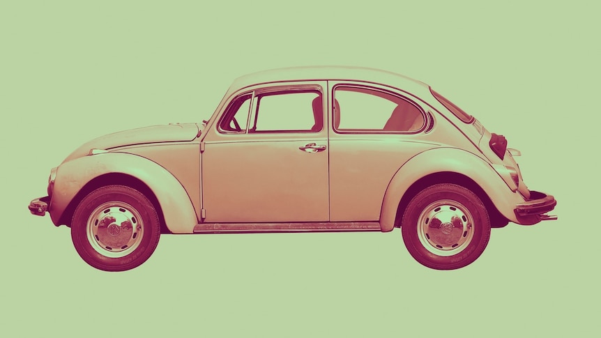 A 1960s-era Volkswagen Beetle in a cream colour is pictured on its side-profile with a green hue.