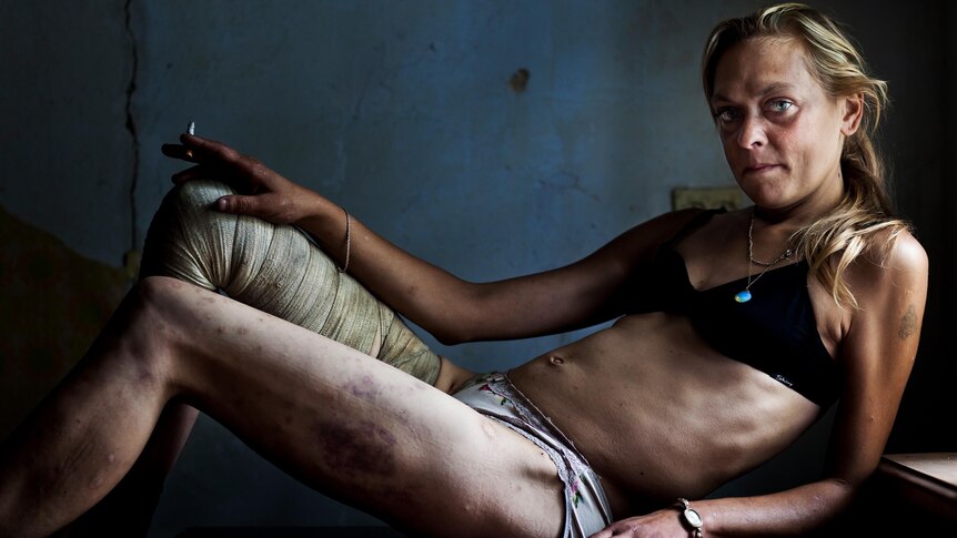 Maria, a drug addict and sex worker, in between clients in a room she rents in Kryvyi Rig, Ukraine.