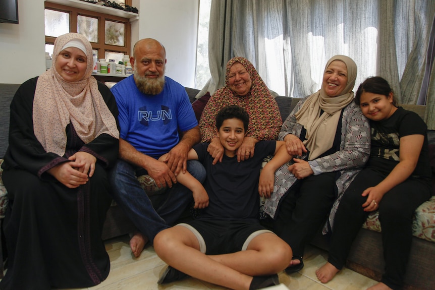 Asma' sits with her mother and brother's family