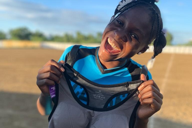 A girl holds a sports bra in front of her chest.