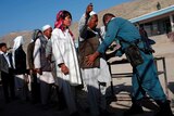 An Afghan policeman searches voters outside a polling station in Kabul June 14, 2014.