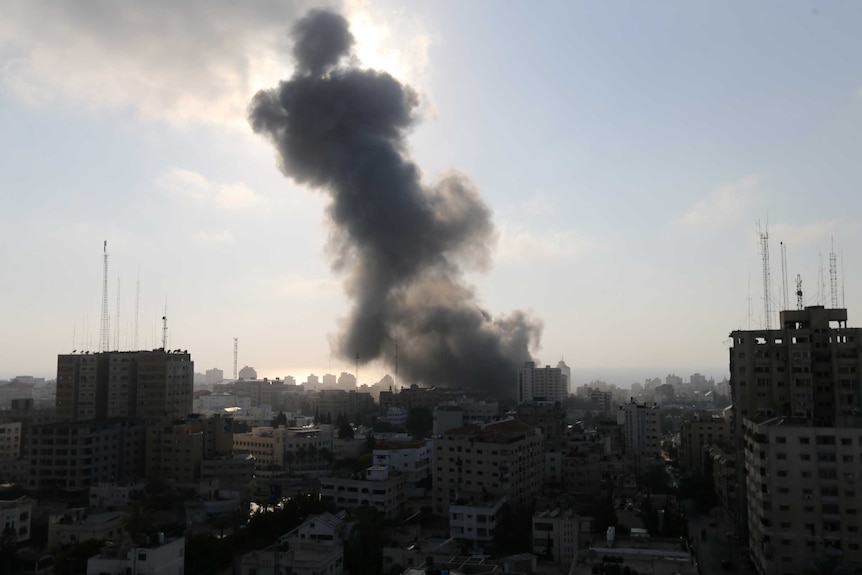 Smoke rising from a cluster of tall buildings.