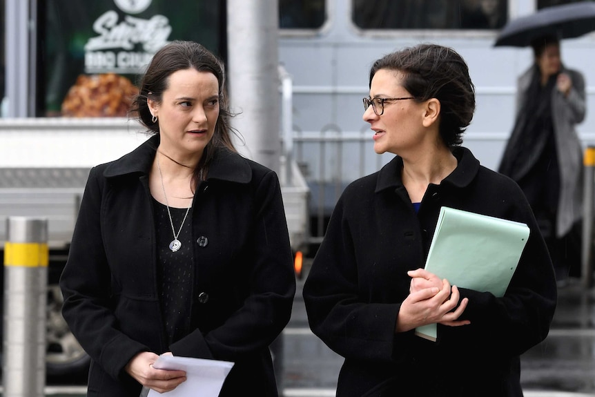 Shonica Guy (left) and Jennifer Kanis walk towards court talking to each other.