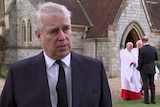 prince andrew talking to camera with church in background