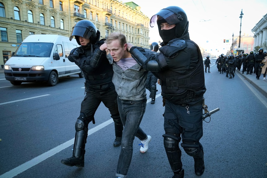 Russian policemen detain a demonstrator protesting against mobilisation in St. Petersburg