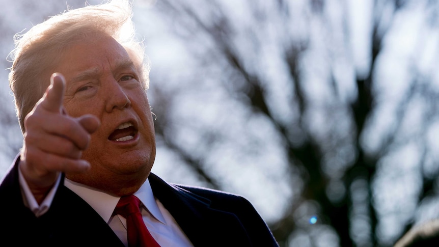 President Donald Trump points his finger as he speaks to reporters