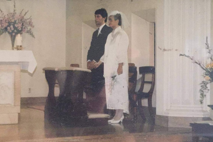 Couple stand at the alter in a church to be married.