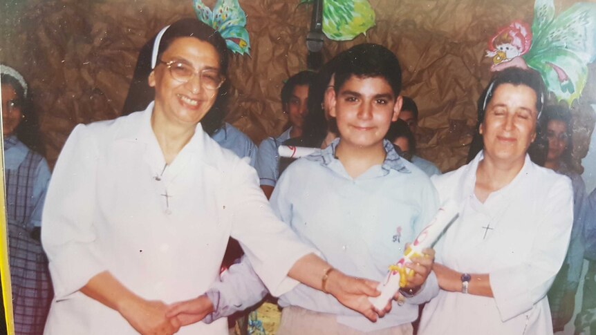 Two catholic nuns in Lebanon standing on either side of Fadi Chalouhy.