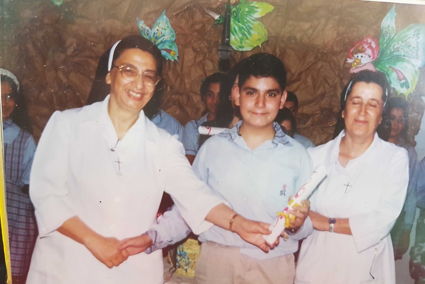 Two catholic nuns in Lebanon standing on either side of Fadi Chalouhy.