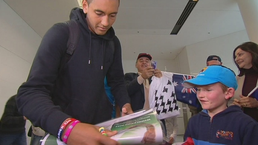 Charlie, 7, has his poster autographed by Nick Kyrgios at Canberra Airport.