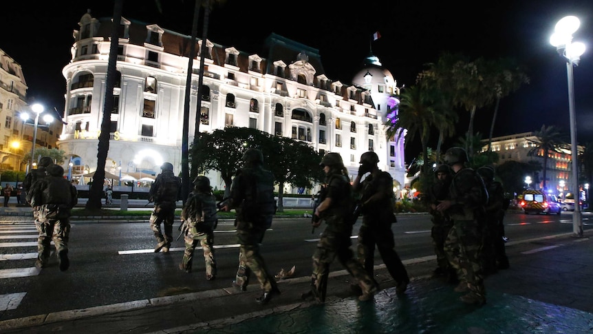 French soldiers advance on the street in Nice, France.