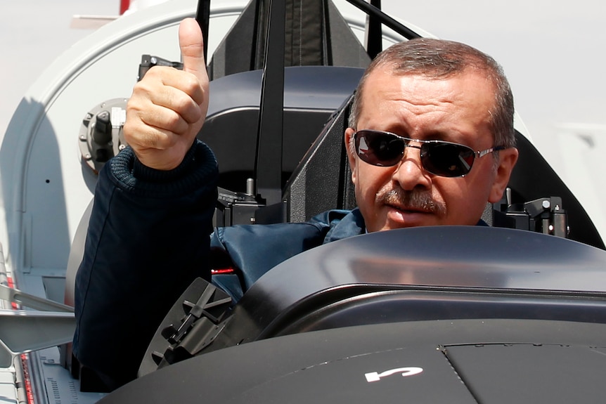 Turkish prime minister Tayyip Erdogan gives a thumbs-up sign from the cockpit of the aircraft 'Hurkus'.