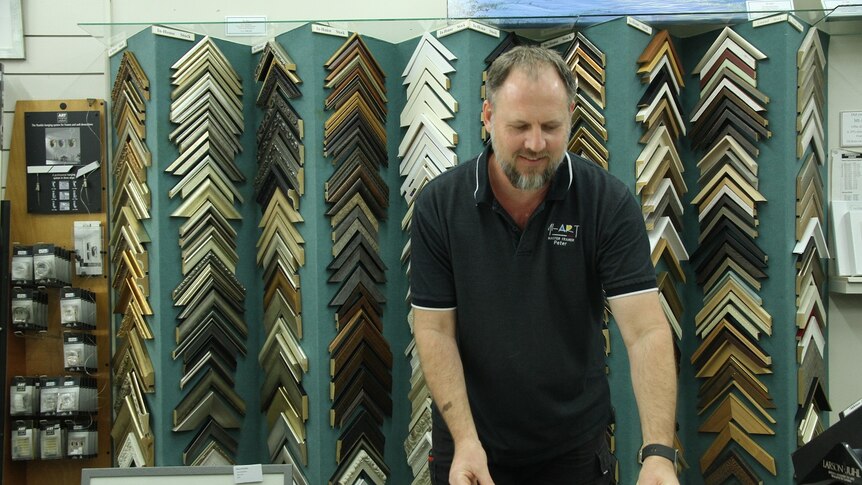 a man behind a counter in an art store