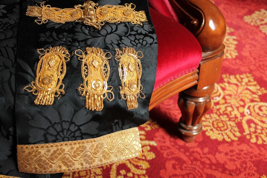 The left sleeve of the mayoral robe with delicate gold trim.