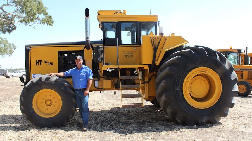Organic farmer Andrew Taylor stands in front of the Upton HT-14 tractor.