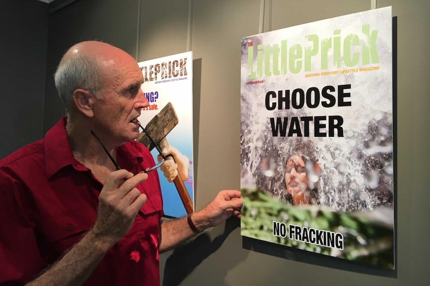 David Hancock looking at a satirical poster.