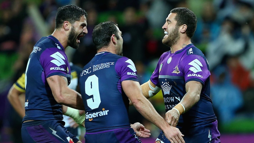 Storm players celebrate a try against the Cowboys