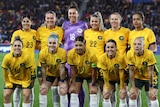 A group of female soccer players pose for a team photo