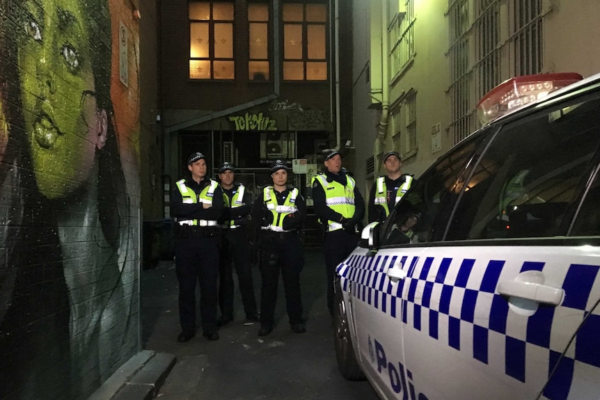 Police guard the back entrance to the Athenaeum Club in Melbourne where Margaret Court was due to address a Liberal Party fundraiser