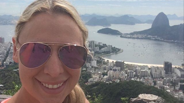 Selfie of Australian archaeologist Jenni Milochis, with a bird's-eye view of a Brazilian coastline city in the background