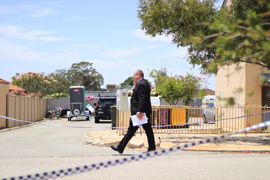 Detectives walking inside a cordoned off area near the unit complex 