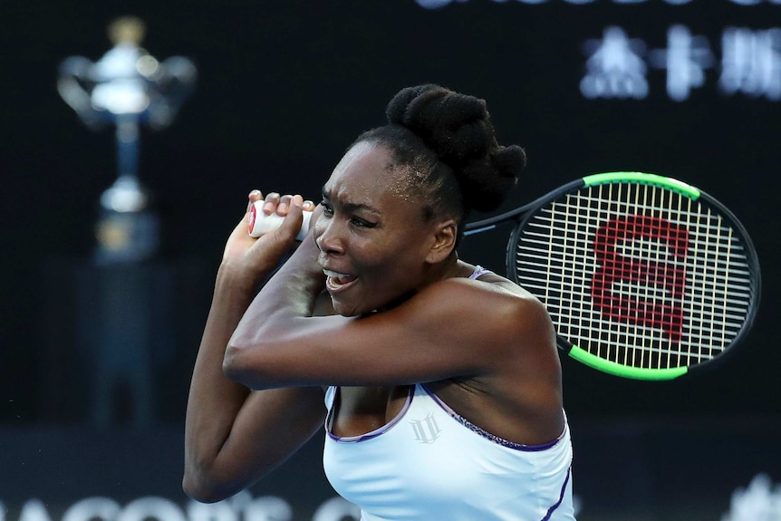 Venus Williams plays a backhand return to her sister Serena during the first set.