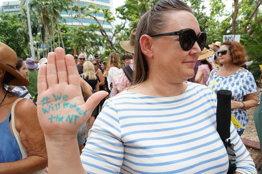 A woman has "#We will protect the NT" written on her palm