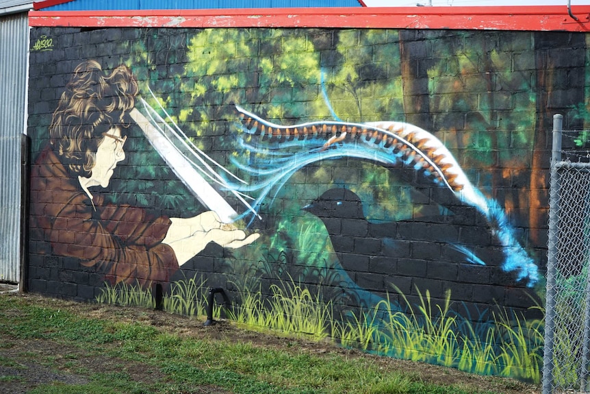 A wall mural depicting a woman, predominantly in shades of blue.