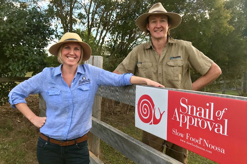 Two people standing at a gate smiling