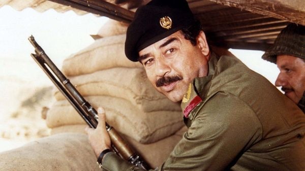 Former Iraqi President Saddam Hussein poses with a gun, date unknown.