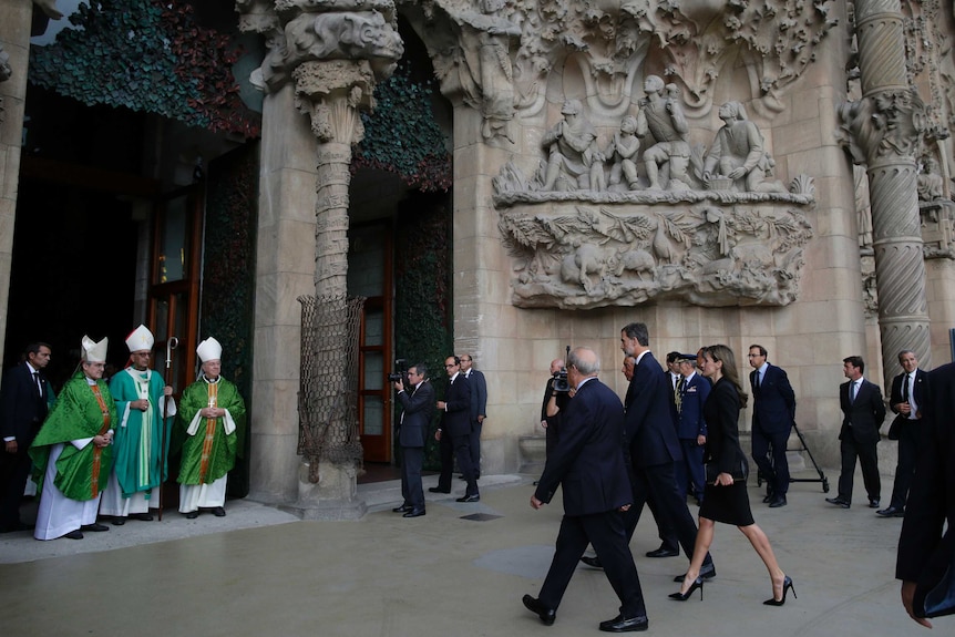 Spain's King Felipe and Queen Letizia walk into Barcelona's Sagrada Familia Basilica.