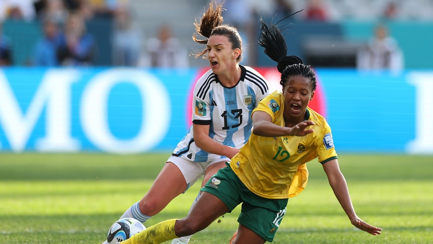 A South African player falls to the ground while being challenged by an Argentine opponent at the Women's World Cup.