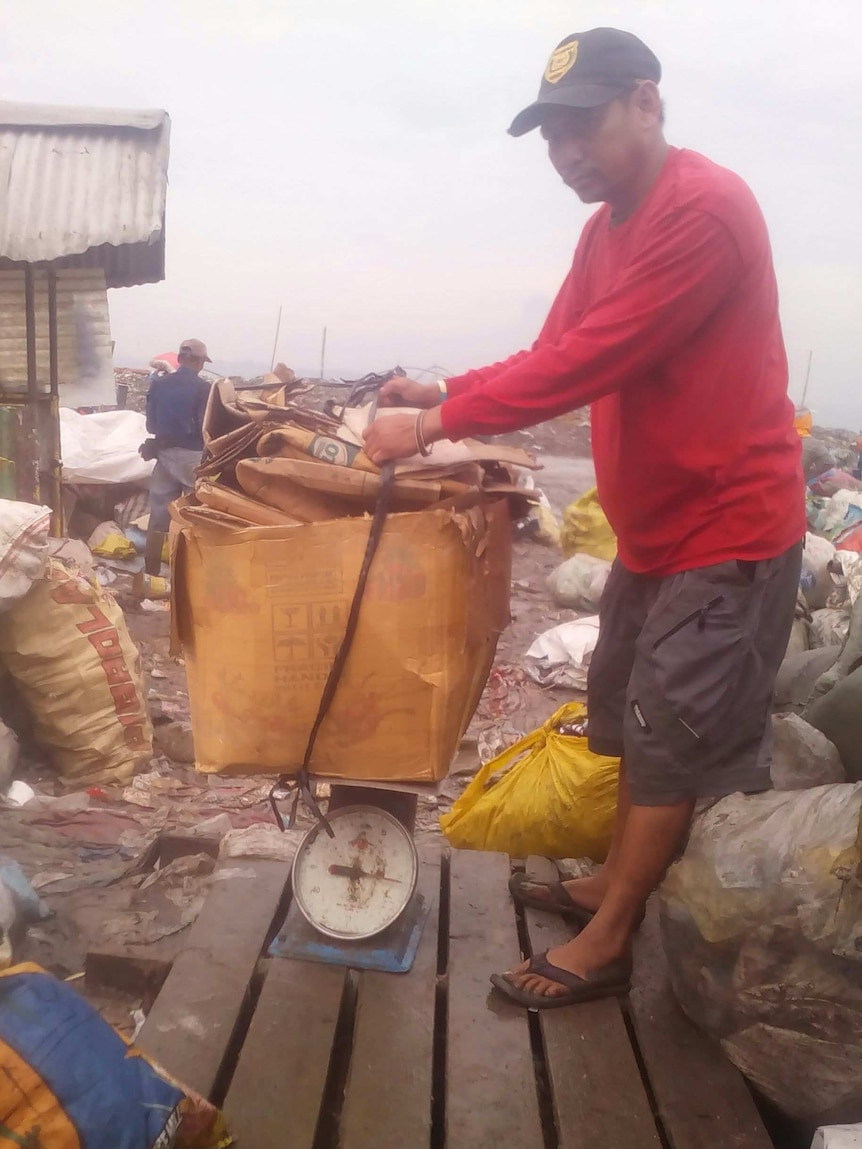 Richard Lluz weighs his collection of recyclables for the day.