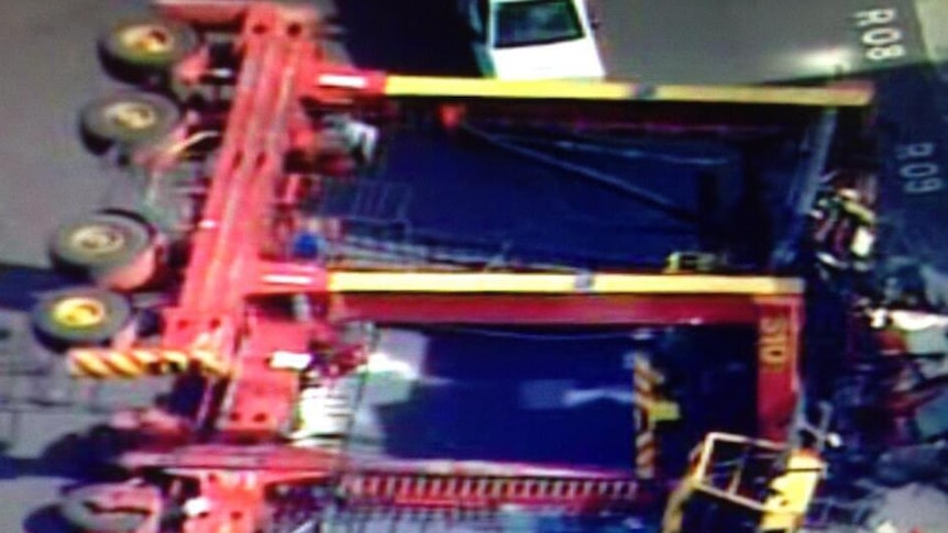 A crane lies on its side after toppling over at a shipping container depot in West Melbourne.