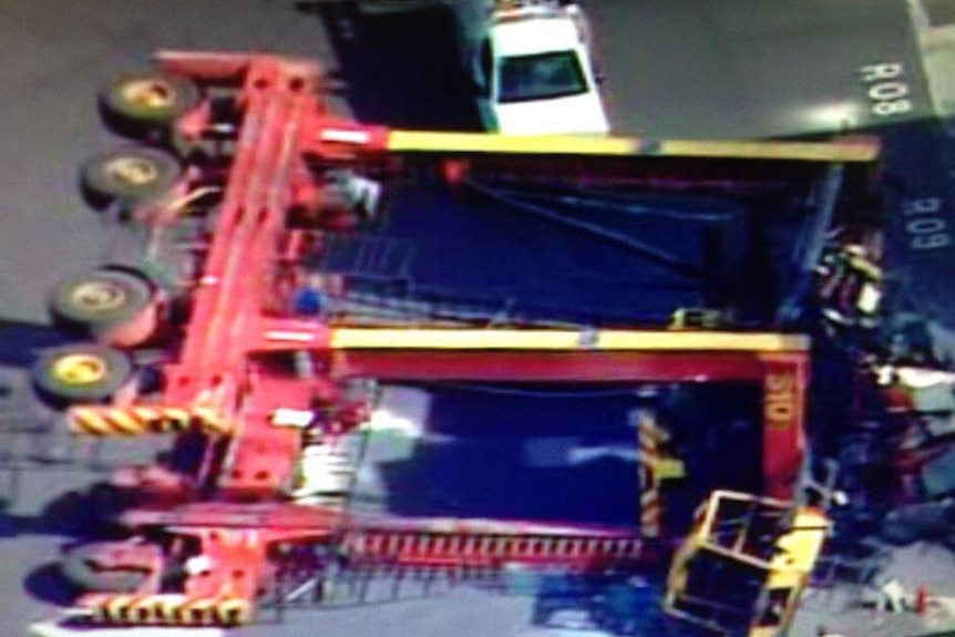 A crane lies on its side after toppling over at a shipping container depot in West Melbourne.