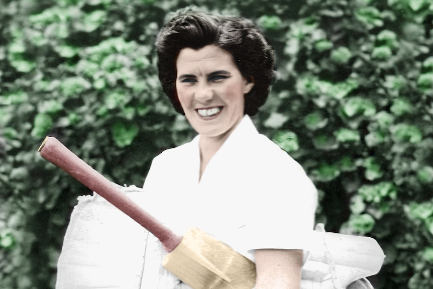 Australian cricket legend Betty Wilson poses for a picture with a bat and pads.