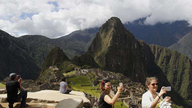 Tourists taking photos with their phones at Machu Picchu.