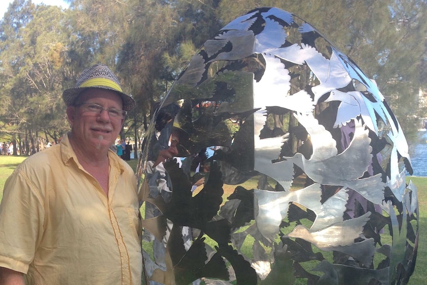 Steve Coburn stands next to his sculpture