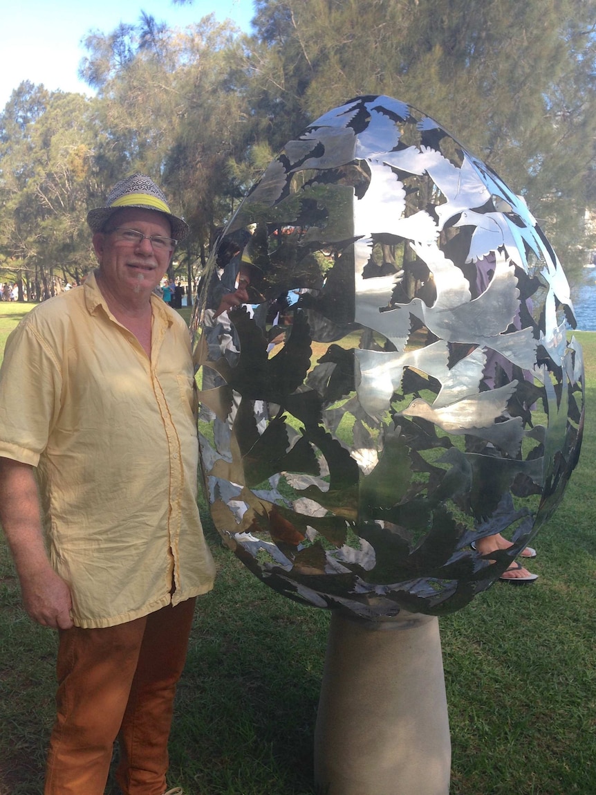 Steve Coburn stands next to his sculpture